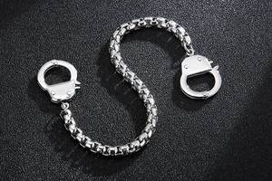 Macro shot of silver handcuff-shaped creative links on a square box chain bracelet