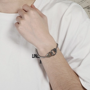 Silver stainless steel ball chain bracelet with double handcuff charms on a wrist