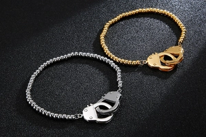 Detail of bead bracelets featuring handcuffs clasp in gold and silver finish