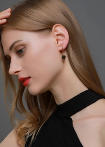 Gros plan sur un mannequin portant des boucles d'oreilles cœur dorées effet miroir 3D