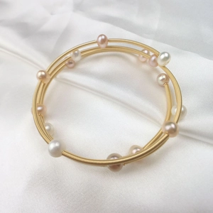 Three-layer gold wire wrap bracelet with white and pink pearls on white silk