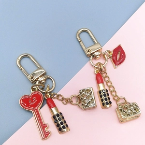 Detailed close-up of golden keychain with enamel lipstick and rhinestone heart charms