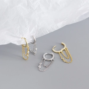 Detail view of gold and silver S925 sterling silver tassel drop earrings with crystals