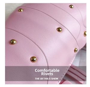 Macro detail of pink lychee leather texture and polished golden rivets on bag strap
