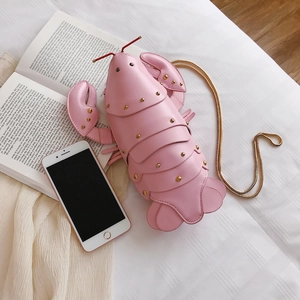 Pink lobster-shaped crossbody bag with gold rivets and chain strap on a white surface