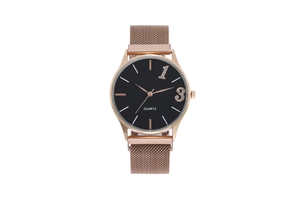 Détail du bracelet magnétique milanais rose doré et du cadran minimaliste noir de la montre