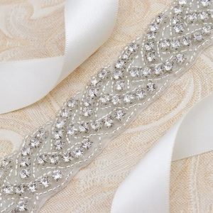 Macro shot of silver rhinestones and beads on white ribbon for bridal belt