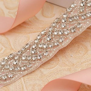 Close-up of sparkling rhinestone bead trim on white mesh for bridal belts and dresses