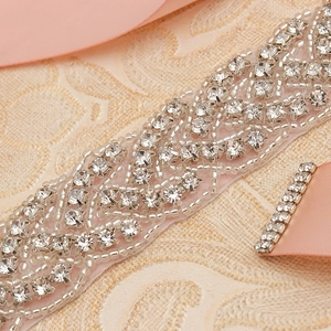 Macro detail of bridal belt with silver rhinestones and pink satin ribbon