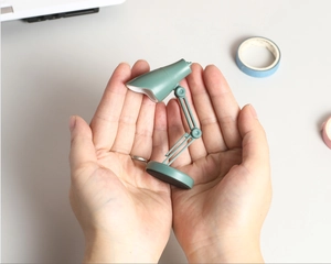 Mini lampe de bureau LED verte tenue en main montrant sa taille compacte portable