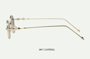 Side view of golden oval sunglasses with unique geometric temples and dark lenses