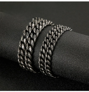Detail of vintage matte black stainless steel NK chain with industrial textured finish