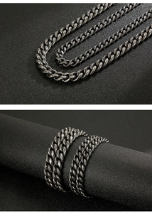 Macro detail of men's vintage grey Cuban link chain with textured stainless steel weave