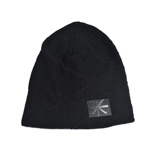 Detail of black knit beanie featuring geometric diamond pattern and metallic star button