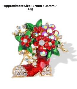 Detailed view of a red Christmas boot brooch with rhinestones and enamel leaves