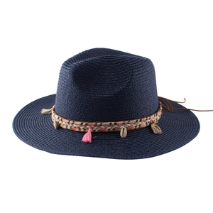 Dettaglio di un cappello di paglia blu con frange bohémien e decorazioni di conchiglie