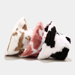 Plush cow print bucket hats in black, brown, and pink faux fur for winter warmth