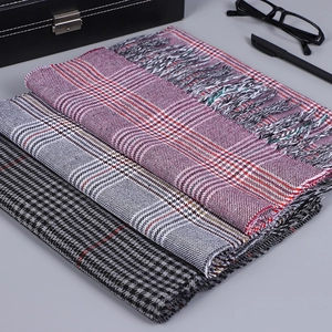 Détail de trois écharpes à carreaux rose, gris et noir avec coffret cadeau élégant