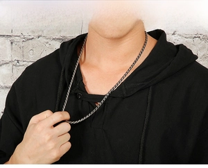 Détail du collier en maille tressée gris foncé porté par un mannequin en sweat à capuche