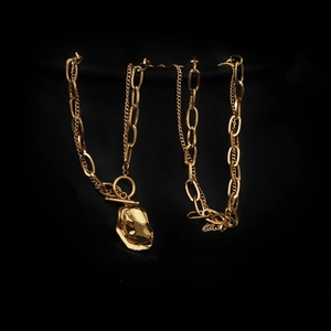 Detailed shot of gold-plated chain necklace with T-bar toggle and irregular lava pendant