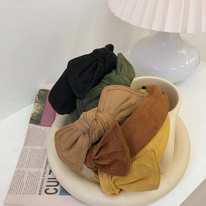 Set of five vintage velvet bow headbands in earthy tones displayed on a ceramic tray