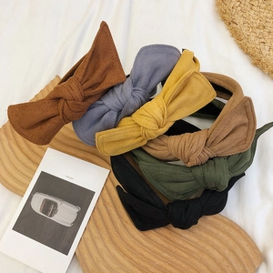 Collection of velvet bow headbands in multiple colors on a wooden display board