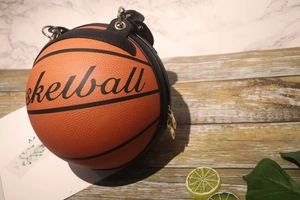 Detail of creative basketball-shaped handbag featuring premium leather texture and golden zippers