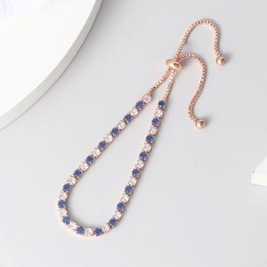 Elegant rose gold bolo bracelet with blue and white cubic zirconia stones in macro view
