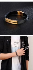 Detail of black woven leather bracelet with gold stainless steel plate on male wrist