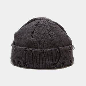 Detail of dark grey ribbed knit beanie showing distressed hole design and street style texture