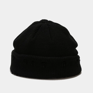 Close-up of the black ribbed knit beanie texture with circular logo on folded cuff
