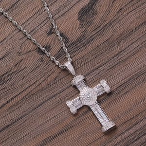 Hip hop silver-toned cross necklace with double-row cubic zirconia on dark wood