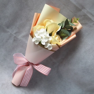 Detailed top view of a mini bouquet with yellow soap roses and pink paper wrap