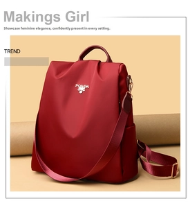 Detail view of water-resistant deep red nylon backpack with adjustable straps and logo