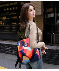Detail of colorful geometric pattern nylon backpack with gold hardware on city street
