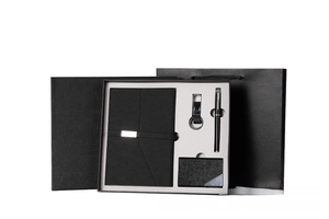 Detail view of business gift set including black notebook, pen, keychain, and card holder