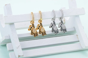 Detail of cute bear drop earrings in gold and silver finish with crystal inlay