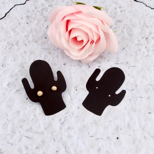 Detail of black cactus-shaped jewelry display cards with gold stud earrings