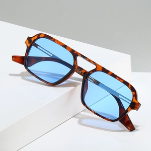 Retro tortoise pilot sunglasses with light blue lenses and double bridge on white pedestal