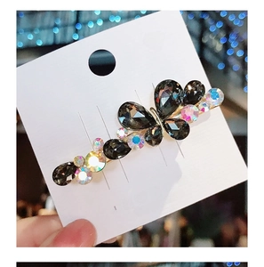 Close-up of butterfly hair clip with colorful Czech crystals on gold metal base