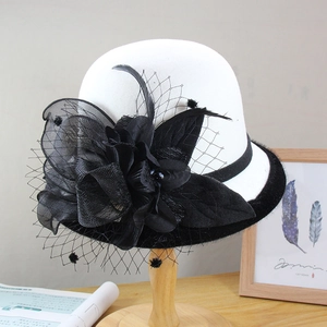 Vintage white wool felt bowler hat with black mesh floral decor and feathers on a stand
