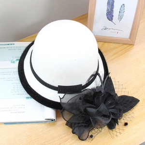 Detail of wool fedora with black velvet ribbon and large mesh flower accent