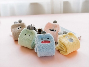 Detail of five colorful coral fleece monster socks with cute cartoon 3D ears and faces