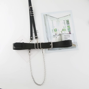 Detail of black leather harness belt with silver metal chains and adjustable buckles