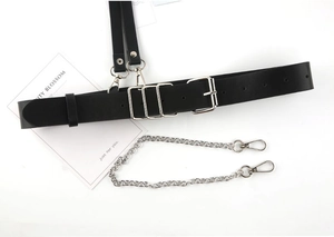 Detail of punk style black leather harness belt with silver metal chain and buckle