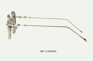 Side view of retro round sunglasses with golden metal frame and geometric relief details