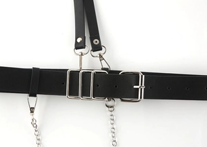Detail of black punk leather belt with silver metal buckles and hanging chains