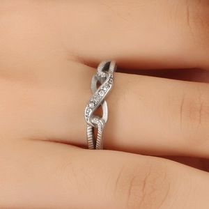 Elegant silver titanium steel infinity ring with white crystals on a woman's finger