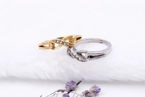 Close-up of interlocking figure-eight rings in gold and silver with cubic zirconia