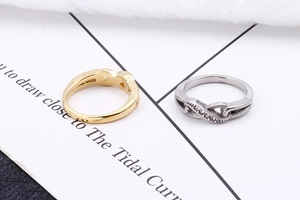 Detail of minimalist figure eight rings in gold and silver with cubic zirconia
